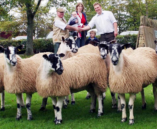 With the 2010 Skipton Mule gimmer lamb champions to the fore, Ashley and Rachel Caton and family are congratulated by judge Brian Watchorn, Newark, left